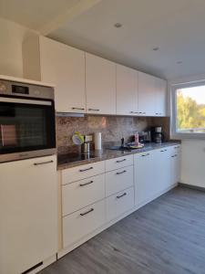 a kitchen with white cabinets and a window at Ferienwohnung Mack 1 in Wernigerode