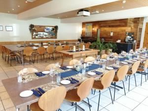 een grote eetkamer met tafels en stoelen bij Hotel Restaurant Knobelboden in Oberterzen