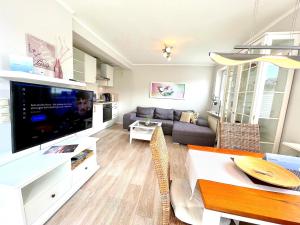 sala de estar con sofá y TV en M4 - Apartmenthaus Marienburger Str 4 - FERIENDOMIZIL HOLLICH en Grömitz
