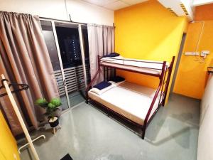 a room with two bunk beds and a window at The Cocoon Capsule Hotel in Cameron Highlands