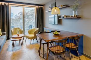 Downtown Apartments Mitte-Wedding في برلين: مطبخ وغرفة معيشة مع طاولة وكراسي