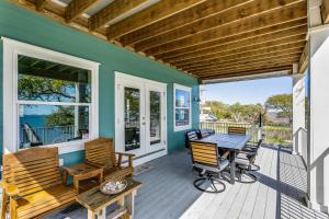 una terraza con mesa y sillas en una casa en Welcome to Sea Cow, en Oriole Beach