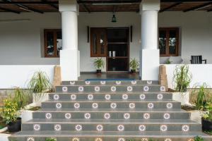 a house with stairs leading to the front door at The Inglewood Bungalow in Yercaud