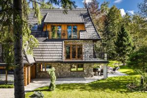 ein Steinhaus mit schwarzem Dach in der Unterkunft Villa 9A in Zakopane