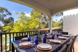 uma mesa azul com pratos e copos numa varanda em Casa Palmeiras Luxury Tranquil area BBQ Large Pool em Carvoeiro