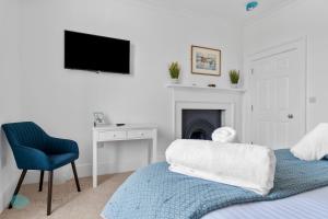 a bedroom with a bed and a chair and a tv at 1 Bed- Hawkyns By Pureserviced in Plymouth