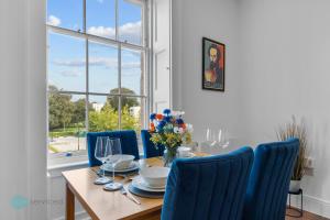 a dining room with a table and blue chairs at 1 Bed- Hawkyns By Pureserviced in Plymouth