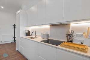 a kitchen with white cabinets and a sink at 1 Bed- Hawkyns By Pureserviced in Plymouth