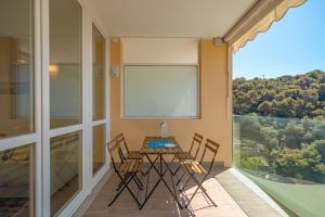 una sala da pranzo con tavolo e sedie sul balcone di Appartamento incantevole con piscina a Vallecrosia