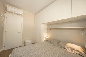 una camera con un letto e una parete bianca di Appartamento incantevole con piscina a Vallecrosia