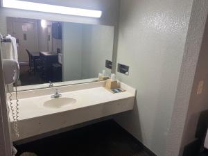 a bathroom with a sink and a large mirror at DIAMOND INN in Forrest City