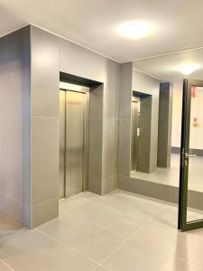 a hallway with elevators and mirrors in a building at Apartament Nowomiejska in Suwałki