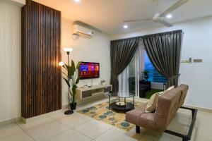 sala de estar con sofá, TV y silla en 2R1B/Seaview Tropical /1~8Pax/Gurney Mansion One, en George Town