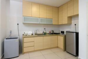 a kitchen with wooden cabinets and a refrigerator at 2R1B/Seaview Tropical /1~8Pax/Gurney Mansion One in George Town