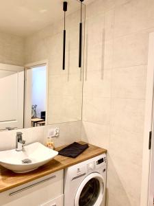 a bathroom with a washing machine and a sink at Apartament Nowomiejska in Suwałki