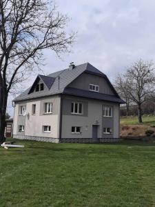een groot wit huis met een zwart dak bij Contryside holiday house, for even better energy sourcing in Detva