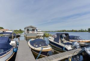 a group of boats are docked at a dock at Woonark Westeinder with kayaks close to Schiphol Airport in Aalsmeer