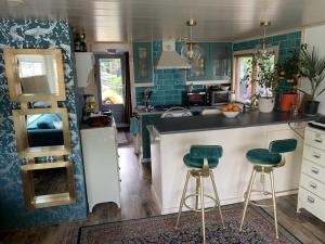 a kitchen with a counter and two bar stools at Woonark Westeinder with kayaks close to Schiphol Airport in Aalsmeer