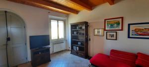 een woonkamer met een rode bank en een televisie bij appartamento in contesto esclusivo in pieno centro in Camerano