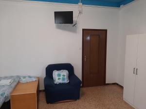 Habitación con silla, cama y TV. en B&B Casa Piva, en Serravalle