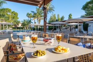 a table with two glasses of wine and food at Estival ElDorado Resort in Cambrils