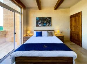 a bedroom with a large bed and a window at Inni Holiday Home with Infinity Pool in Għarb +27 photos