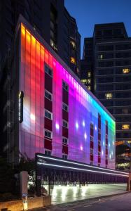 un edificio con luces de colores en el lateral. en ZIP Hotel, en Seúl