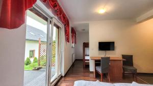 Habitación con escritorio, TV y ventana. en Apartamenty Panorama, en Rychwałd