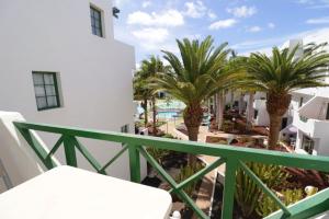 a balcony with palm trees and a pool at casa de los amigos in Tías