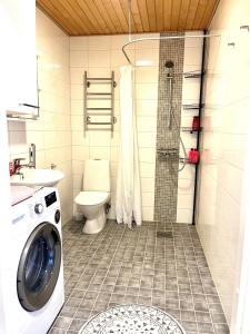 a bathroom with a washing machine and a toilet at Villa Centralen in Helsinki