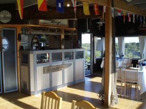 eine Bar in einem Restaurant mit Stühlen und Flaggen in der Unterkunft Kökar Havspaviljong Cottages in Kökar