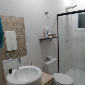 uma casa de banho com um lavatório, um WC e um chuveiro em Hospedagem Sol Nascente em Atibaia