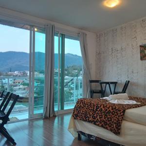 Hospedagem Sol Nascente في أتيبايا: غرفة نوم بسرير ونافذة كبيرة