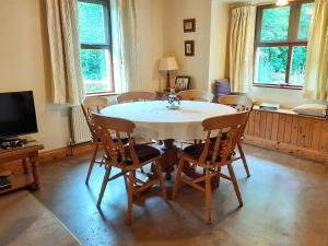 comedor con mesa blanca y sillas en Cornode Cottage, en Garrykennedy