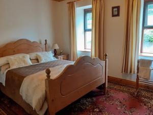 1 dormitorio con 1 cama grande y 2 ventanas en Cornode Cottage, en Garrykennedy