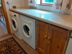 a washing machine in a kitchen with a counter at Cornode Cottage in Garrykennedy