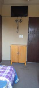 a bedroom with a bed and a television on the wall at Hospedaje San Miguel in Luque