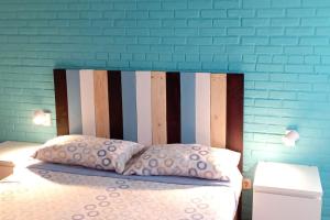 a bed with a wooden headboard and two pillows at Precioso piso-apartamento en barrio de Zaragoza in Zaragoza