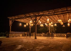 a group of tables and chairs under a pergola at night at Nativa Refugio Escondido in Santa Fe de Antioquia