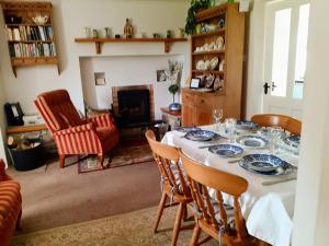 a dining room with a table and chairs and a fireplace at Lackaroe Cottage in Garrykennedy