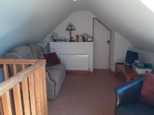 sala de estar con sofá y TV en Lackaroe Cottage, en Garrykennedy