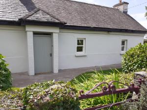 una casa blanca con garaje en Lackaroe Cottage en Garrykennedy