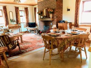 uma sala de jantar com uma mesa e cadeiras e uma lareira em Fraoch Cottage em Garrykennedy