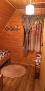 a bedroom with a bed and curtains in a cabin at Domki Obertyny in Wetlina