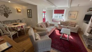 a living room with couches and a dining room at The Nook - Charming cottage, modern living with original features, perfect private garden in Dittisham