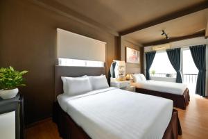 a hotel room with two beds and a window at The Noble Swan Wood Park Hotel in Ho Chi Minh City