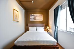 a bedroom with a bed and a window at The Noble Swan Wood Park Hotel in Ho Chi Minh City