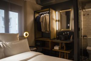 Schlafzimmer mit einem Bett, einem Spiegel und einem Schrank in der Unterkunft Letoh Letoh Gran Vía in Madrid