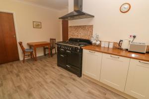 a kitchen with a black stove and a table at Yngywidden in Penzance