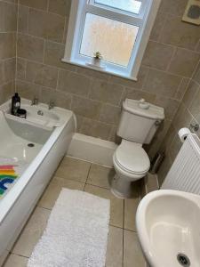 W łazience znajduje się toaleta, wanna i umywalka. w obiekcie The White House - Cheerful 3 Bedroom home in Wigan - Ince - sleeps 7 - parking - Work space - Great motorway links w mieście Ince-in-Makerfield